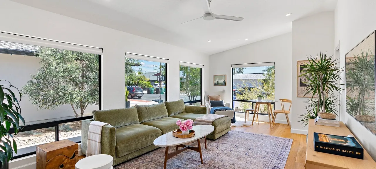 Living room addition with large sliding windows, sectional sofa, and hardwood flooring