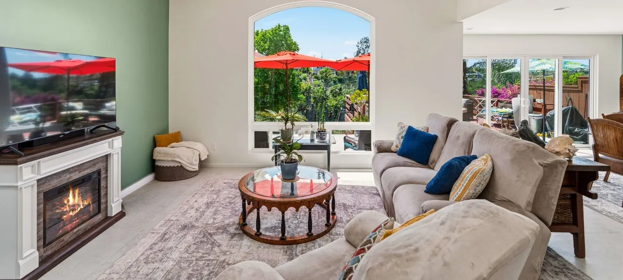 Living room addition with fireplace, wall-mounted TV, and arched picture window