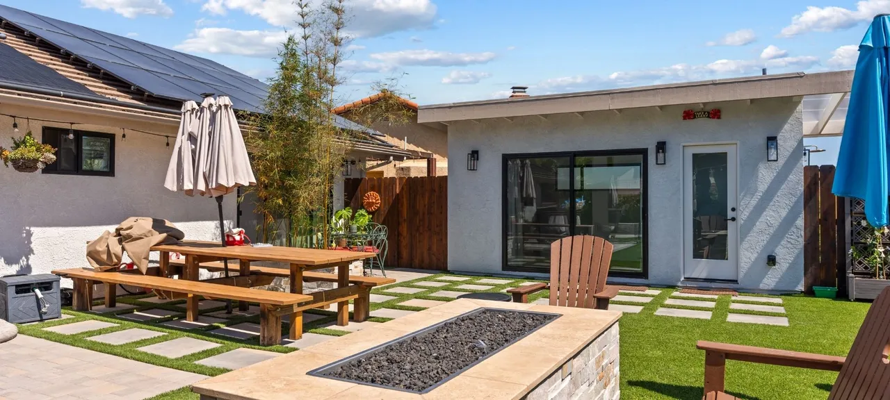 Backyard patio addition with fire pit, covered seating area, and picnic table