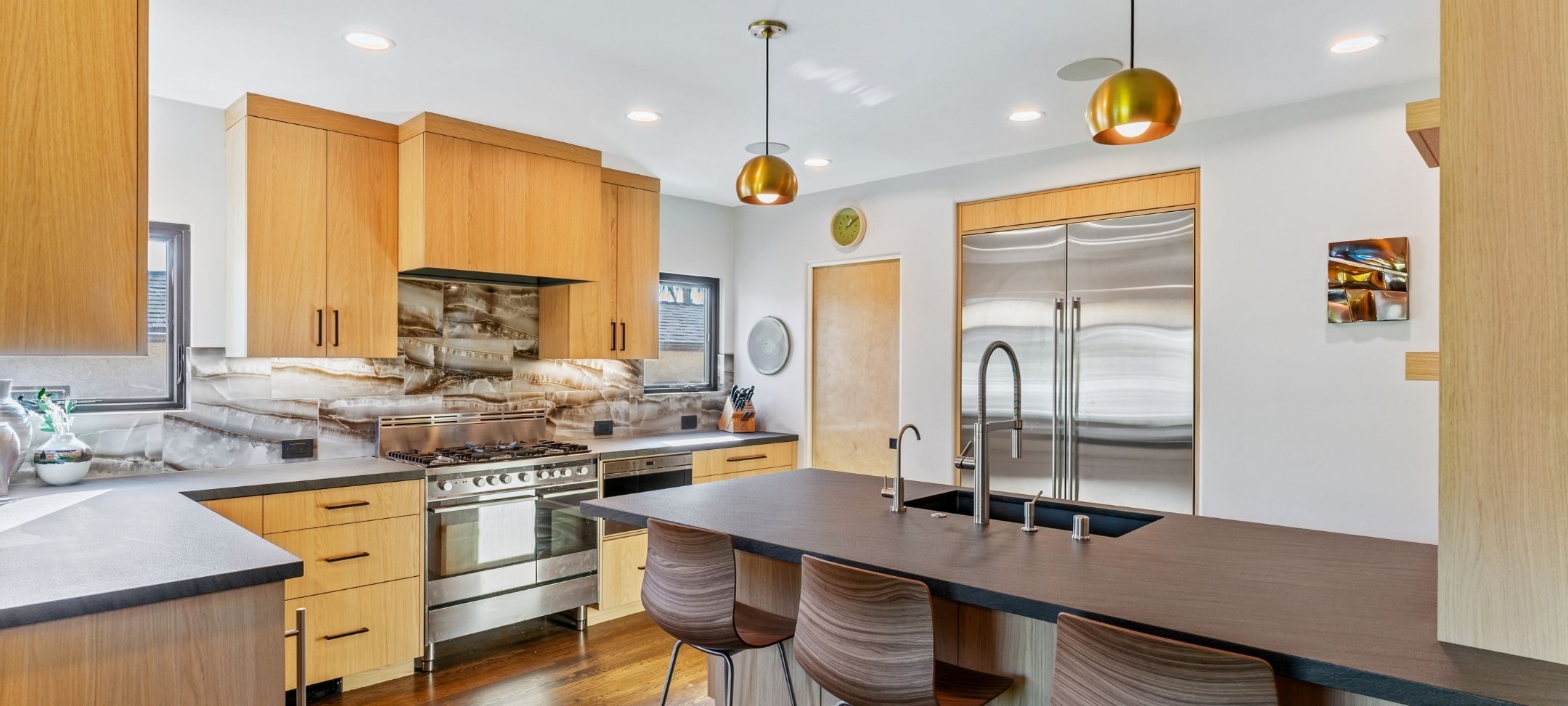 ADU kitchen remodel with wood cabinetry, brass pendant lighting, and stainless steel appliances
