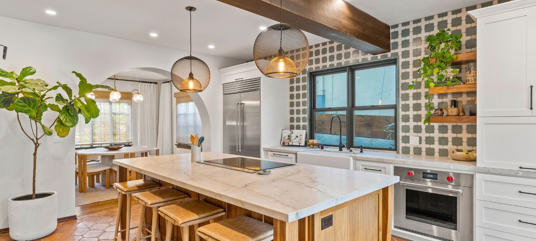 Modern kitchen remodel with black cabinetry accent wall, wood island, and patterned tile backsplash
