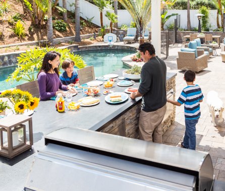 A family enjoys an outdoor meal in their remodeled backyard.