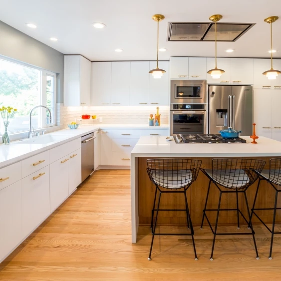 U-shaped San Diego kitchen remodel with white cabinetry, island seating, and warm wood flooring