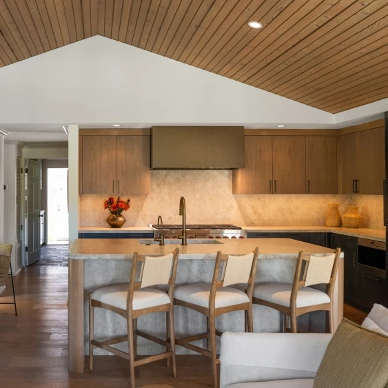 Open-concept San Diego kitchen remodel with wood cabinetry, island seating, and an adjacent living room
