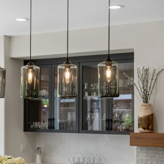 Glass pendant lights and recessed lighting in a modern San Diego kitchen remodel