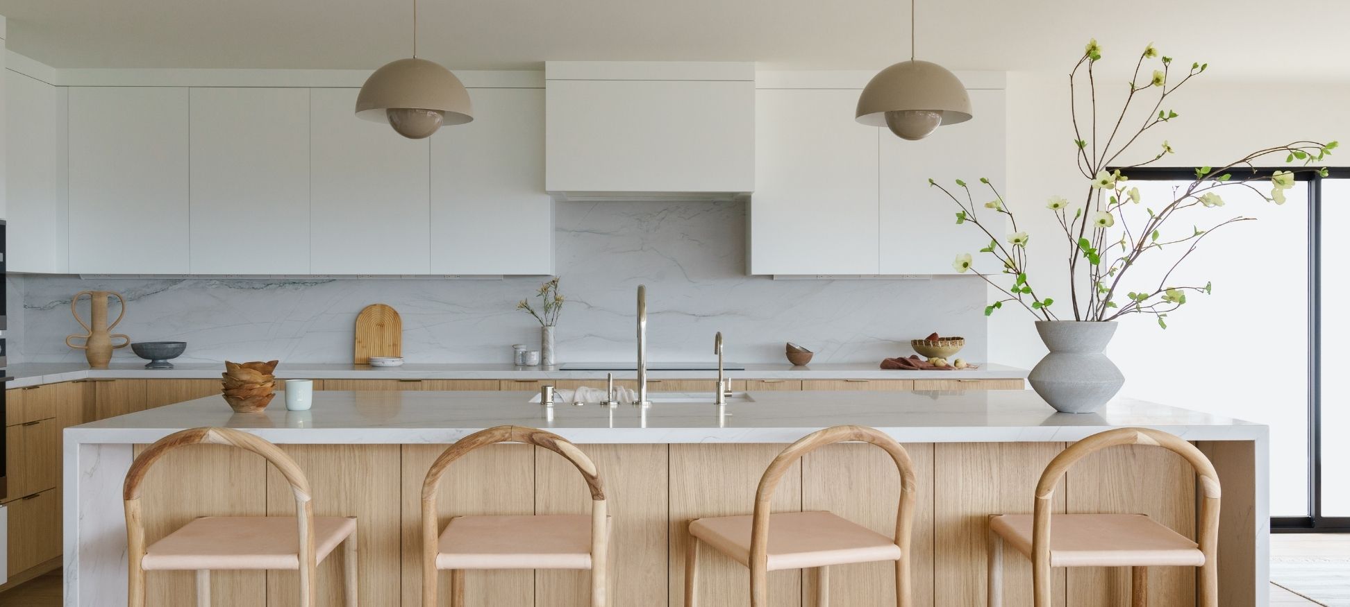 Light wood kitchen remodel with white cabinetry, marble backsplash, and dome pendant lighting