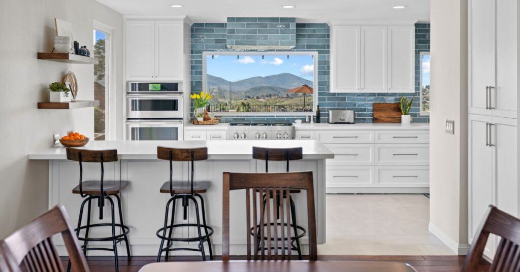 Kitchen featuring custom white cabinets, full-height pantry storage, soft-close drawers, and a functional island designed for organization and efficiency.