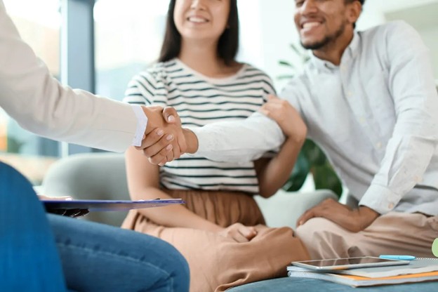 People shaking hands at a table in a modern office