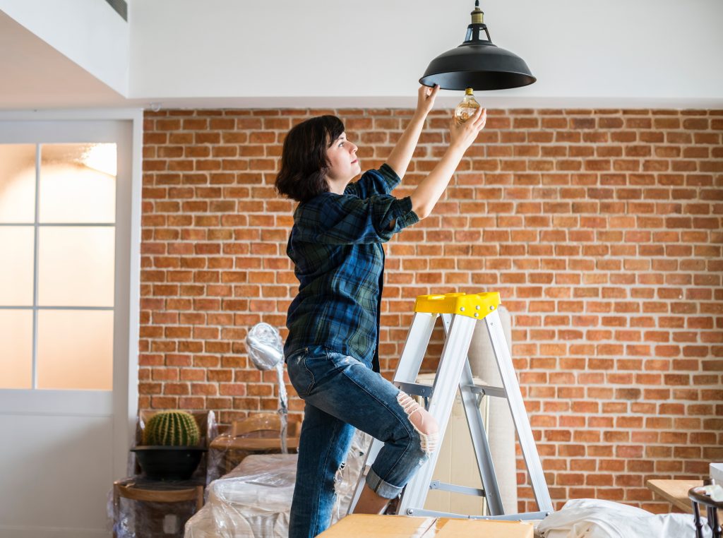 Woman changing lightbulb of a new home