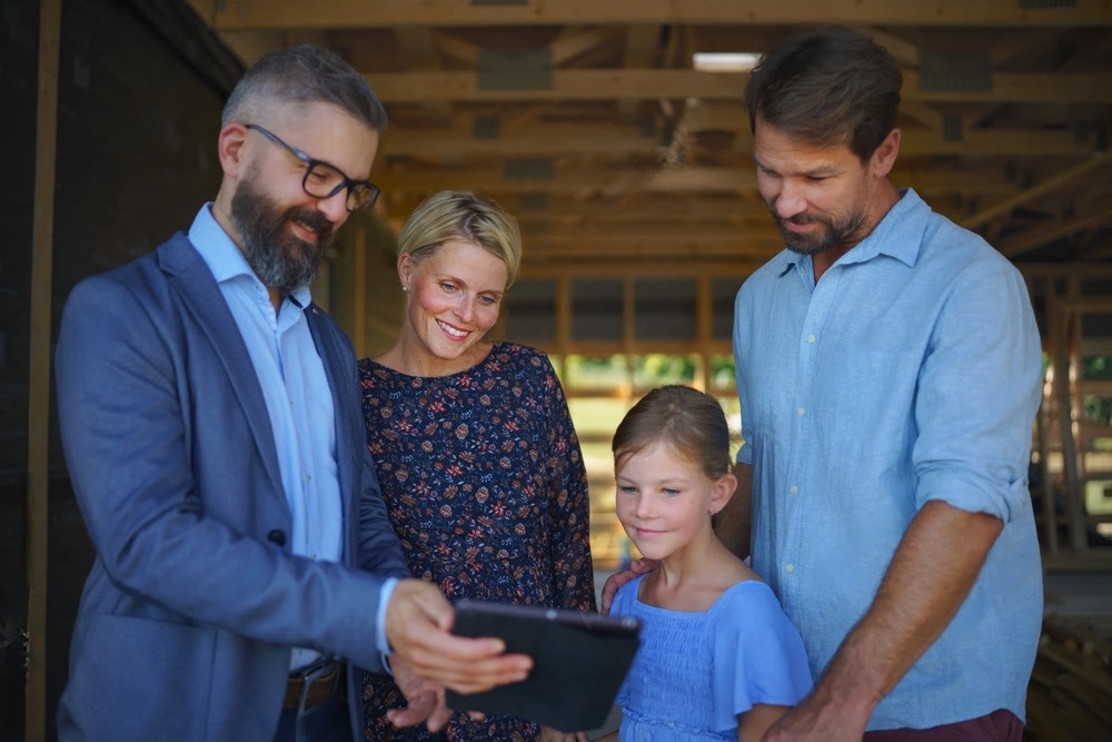 parents of young girl discussing new home project with builder 