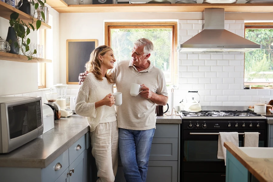 Happy middle-aged couple talking in a cozy modern kitchen