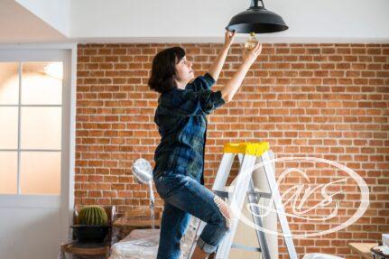 Woman changing lightbulb of a new home