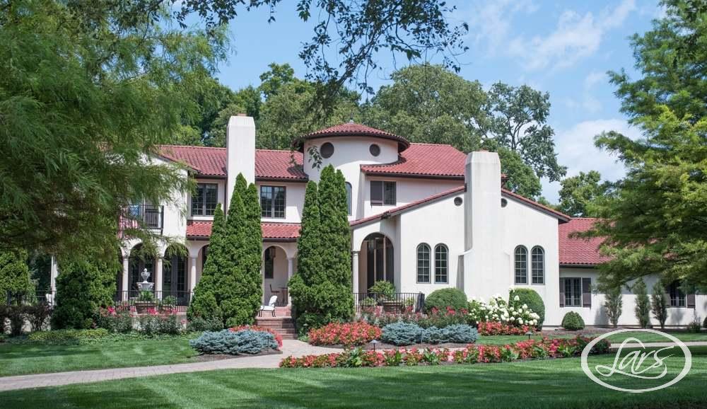 A large Spanish-style home surrounded by greenery.