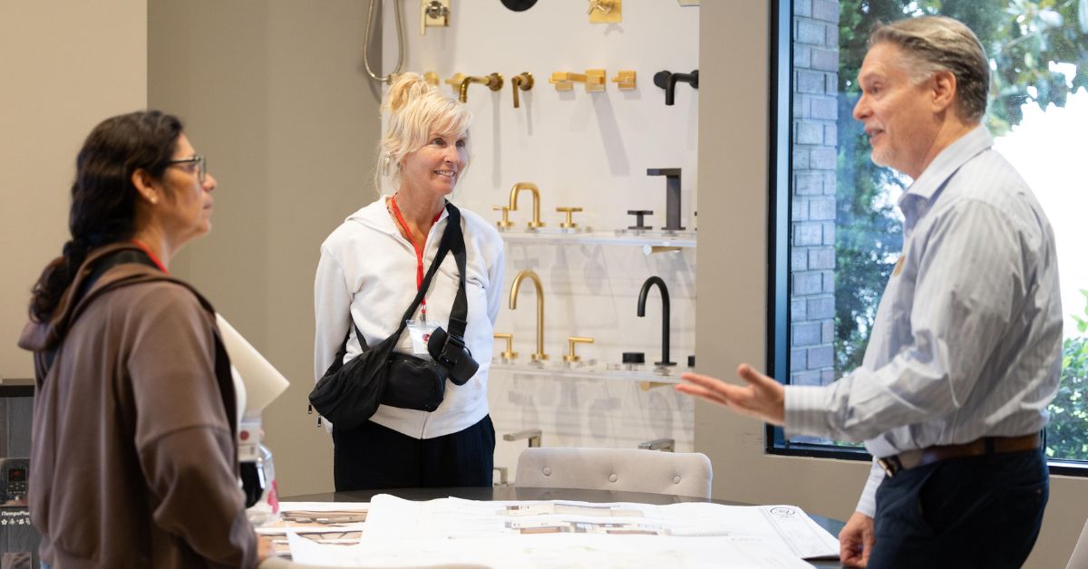 Designer reviewing plans with homeowners in a showroom setting