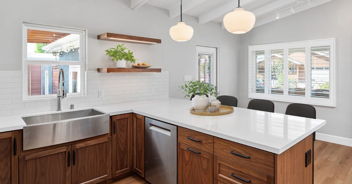 Aging-in-place kitchen remodel with walnut cabinetry, large island, farmhouse sink, and open layout in San Diego home.
