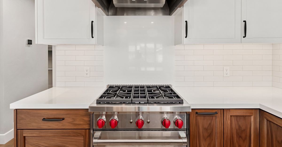 Custom kitchen remodel with Wolf range, white cabinetry, quartz countertops, and walnut lower cabinets in San Diego.