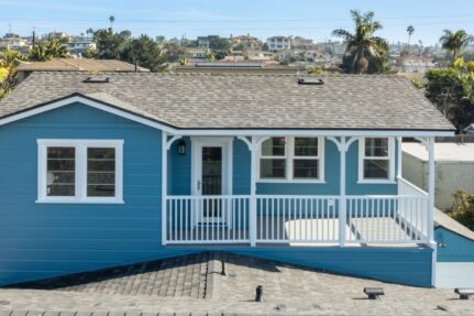 Completed exterior of a Bay Park whole home remodeling project by Lars Remodeling & Design — a 1940s coastal bungalow fully restored and expanded with new siding, updated porch details, skylights, and a fresh two-tone finish that honors the home's original character.