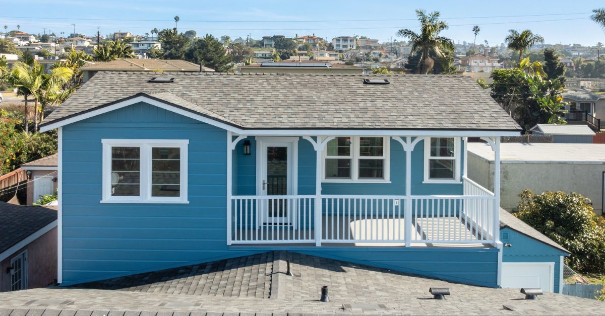 Completed exterior of a Bay Park whole home remodeling project by Lars Remodeling & Design — a 1940s coastal bungalow fully restored and expanded with new siding, updated porch details, skylights, and a fresh two-tone finish that honors the home's original character.
