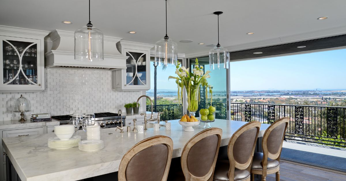 Luxury remodeled kitchen in a San Diego home with integrated indoor-outdoor living, custom cabinetry, marble island, and panoramic views