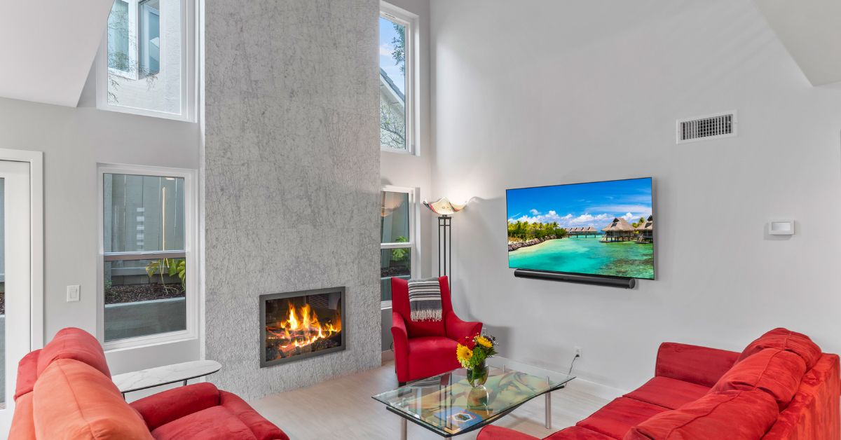 Modernized San Diego living room remodel with updated fireplace, vaulted ceilings, large windows, and contemporary interior finishes