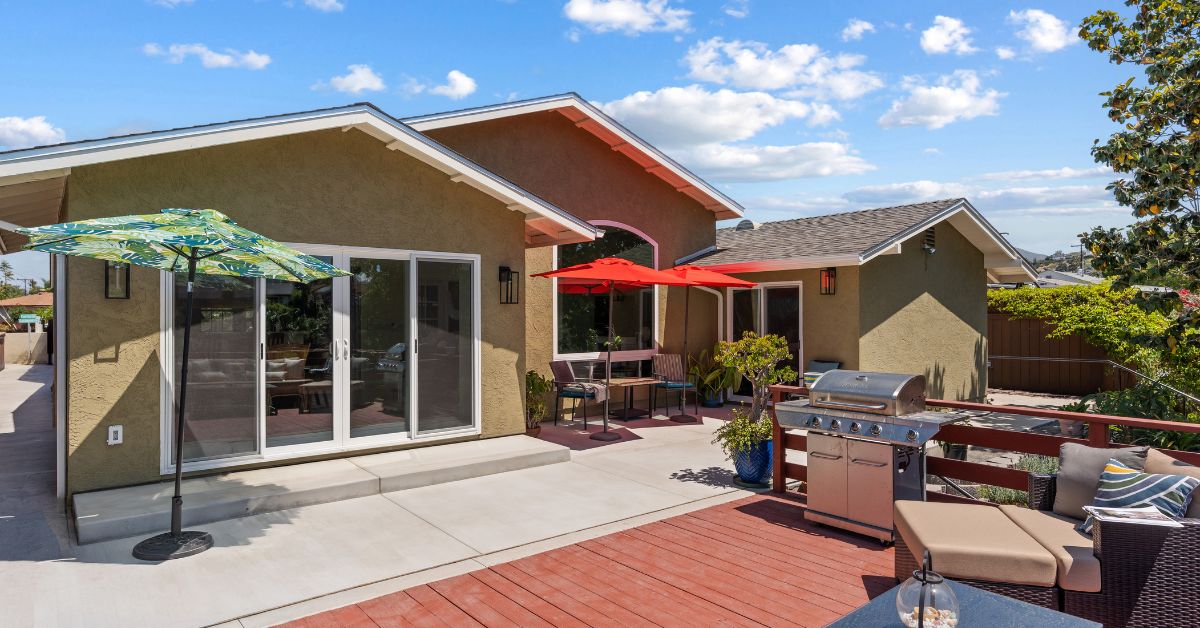 Detached backyard ADU with modern exterior finishes, sliding glass door, and landscaped pathway