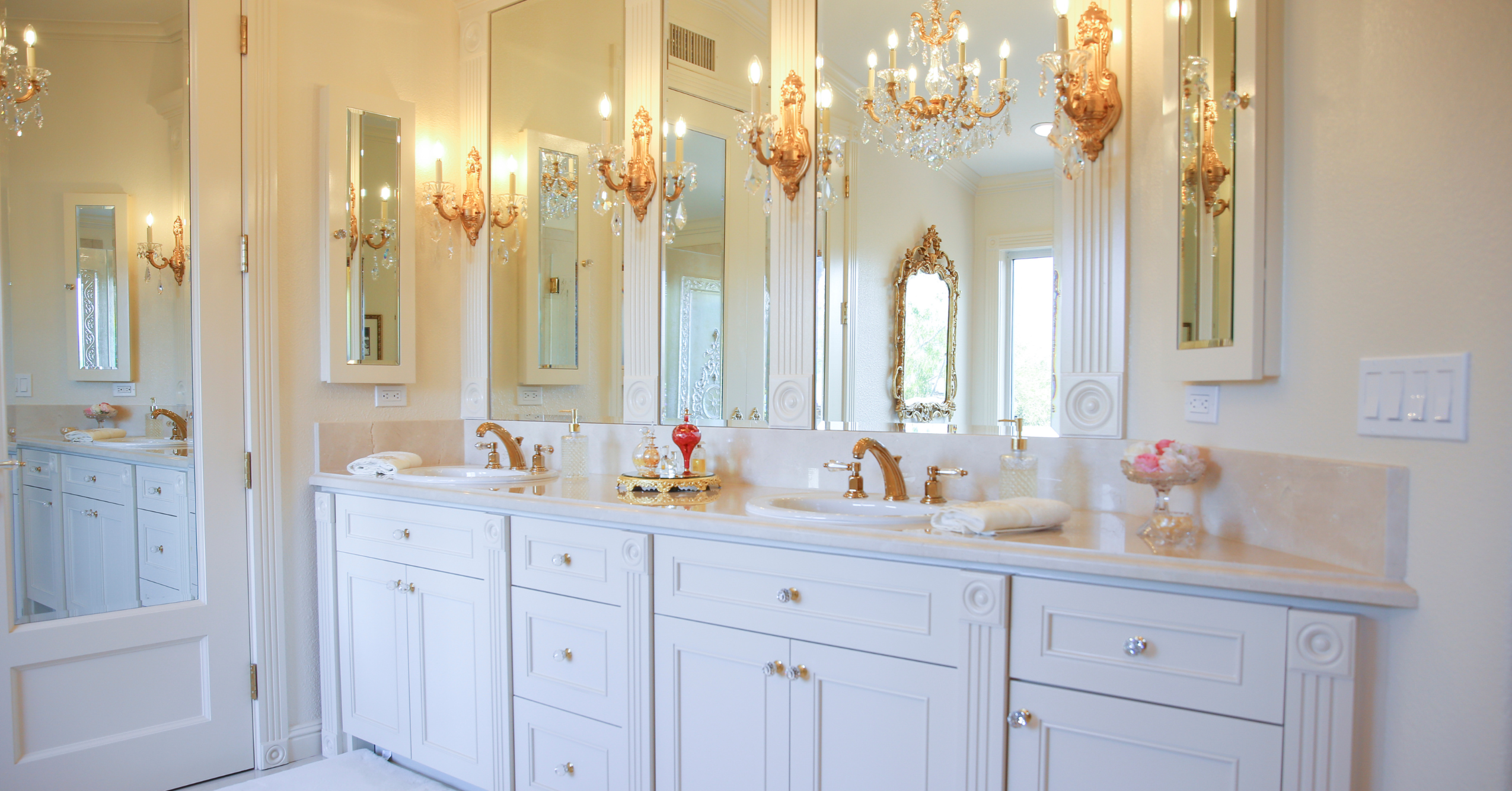 Elegant bathroom remodel with dual vanities, custom millwork, decorative lighting, and premium fixtures.
