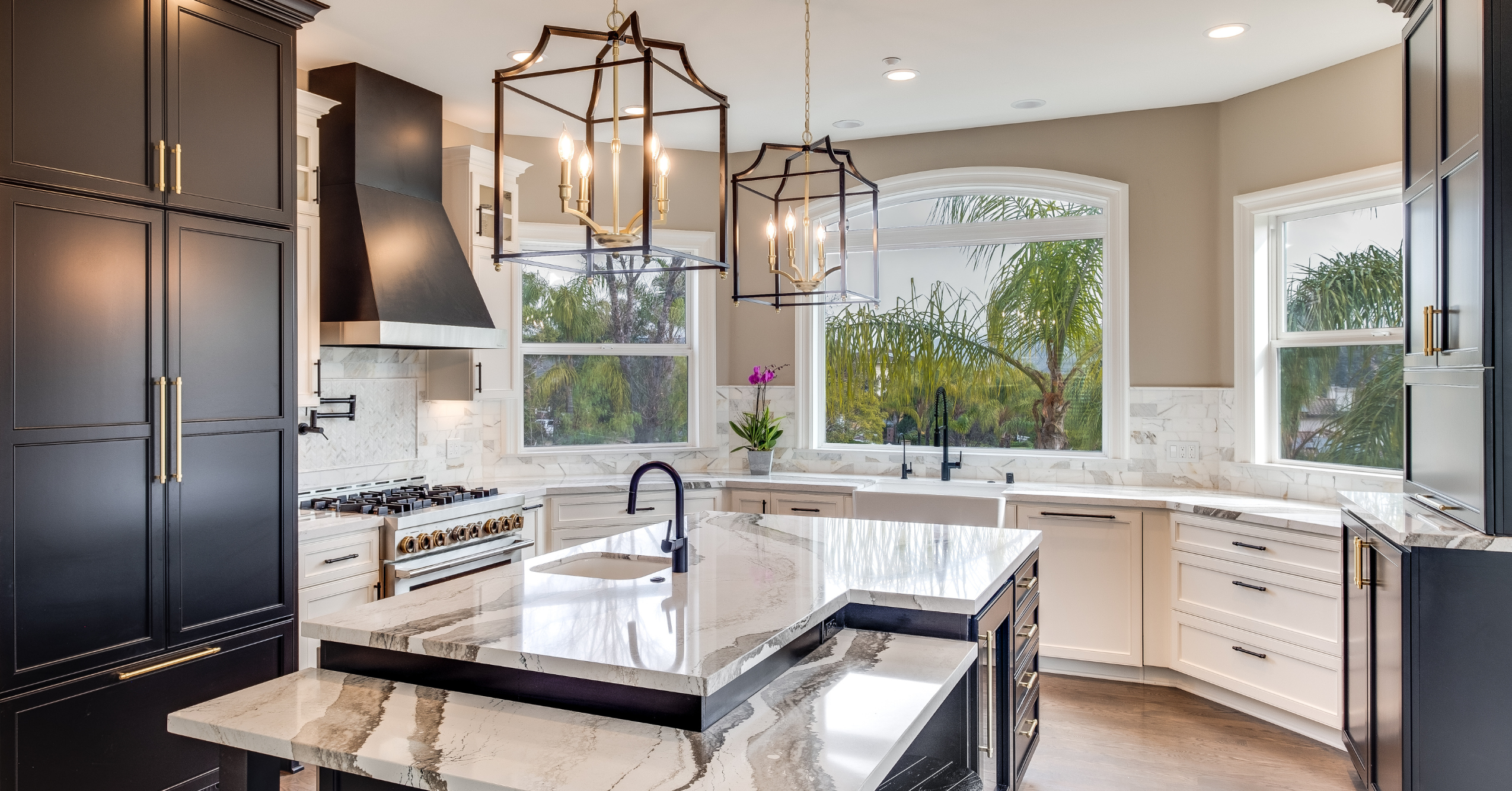 Luxury kitchen remodel with dark custom cabinetry, stone countertops, designer lighting, and premium appliances.