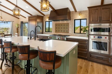 Open-concept kitchen renovation in Vista CA designed to eliminate a cramped layout with a large gathering island, custom cabinetry, vaulted ceilings, Wolf appliances, and seamless connection to adjacent living spaces.
