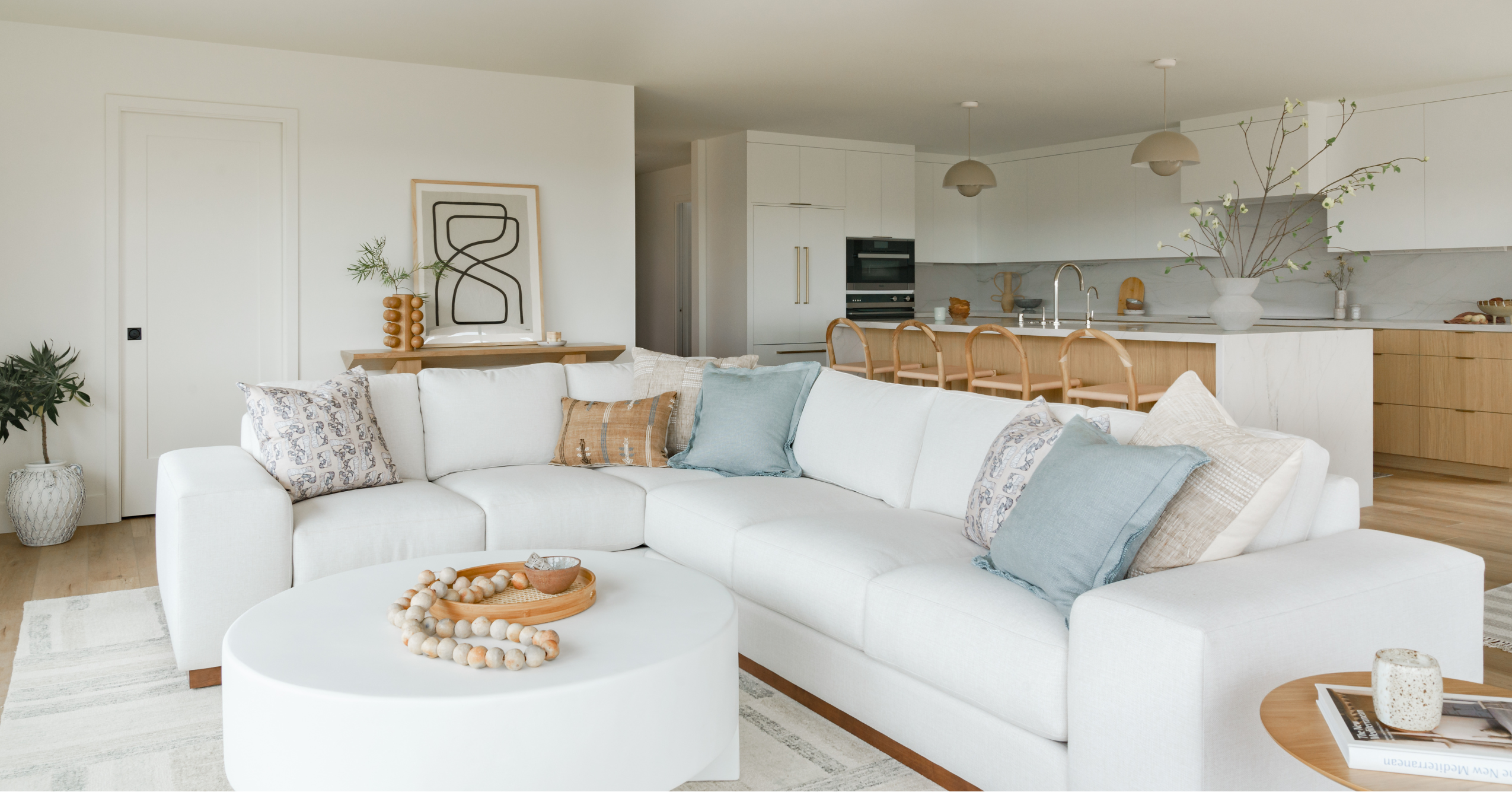 Bright open-concept remodeled living room and kitchen with custom cabinetry, large island, and luxury finishes.