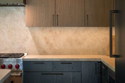 Remodeled kitchen and dining area with custom cabinetry, a large island, professional range, and warm modern finishes.