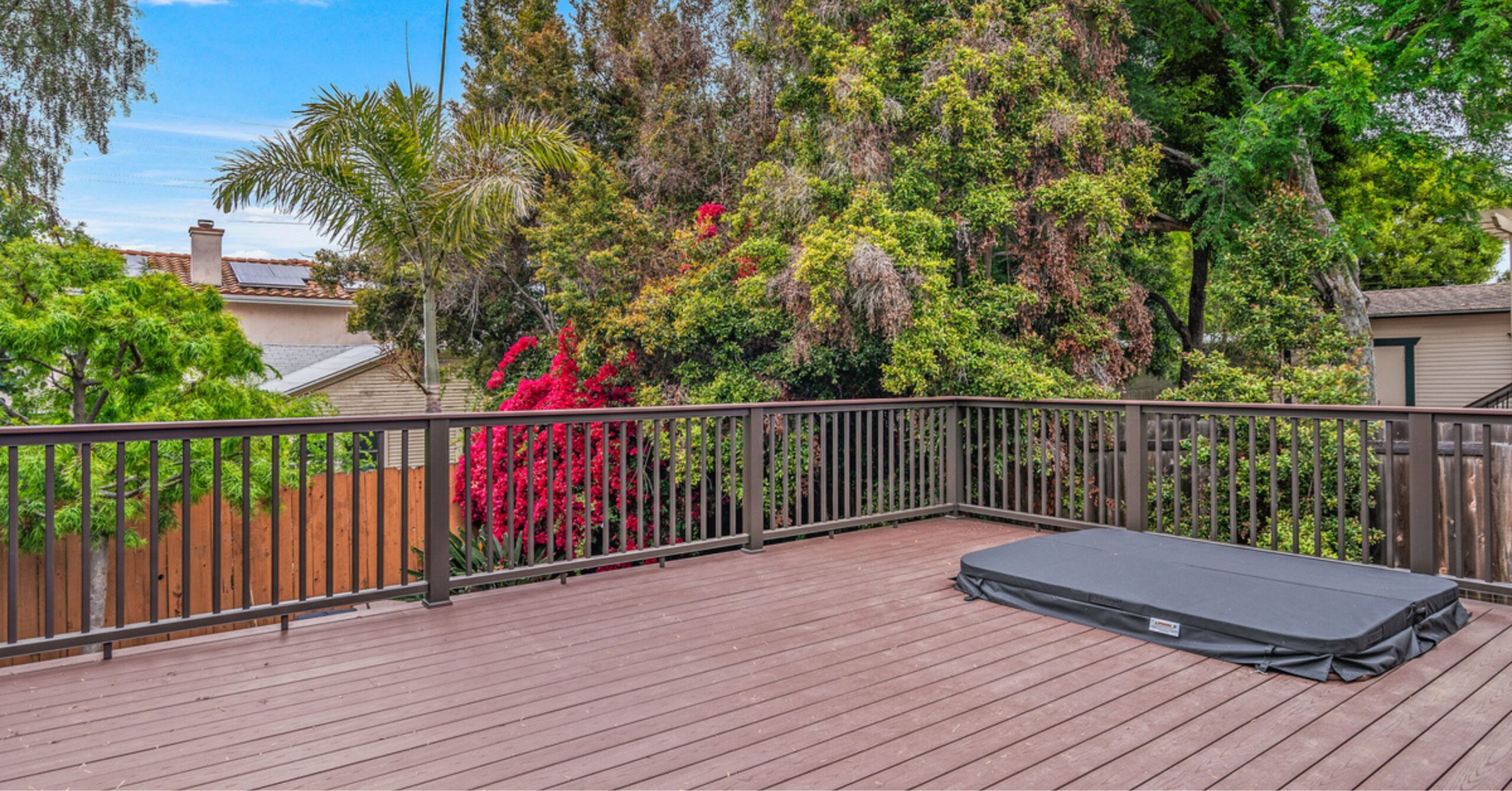 Private deck off the primary suite in a remodeled South Park Craftsman home featuring composite decking, modern railings, and views of mature landscaping for indoor-outdoor living.