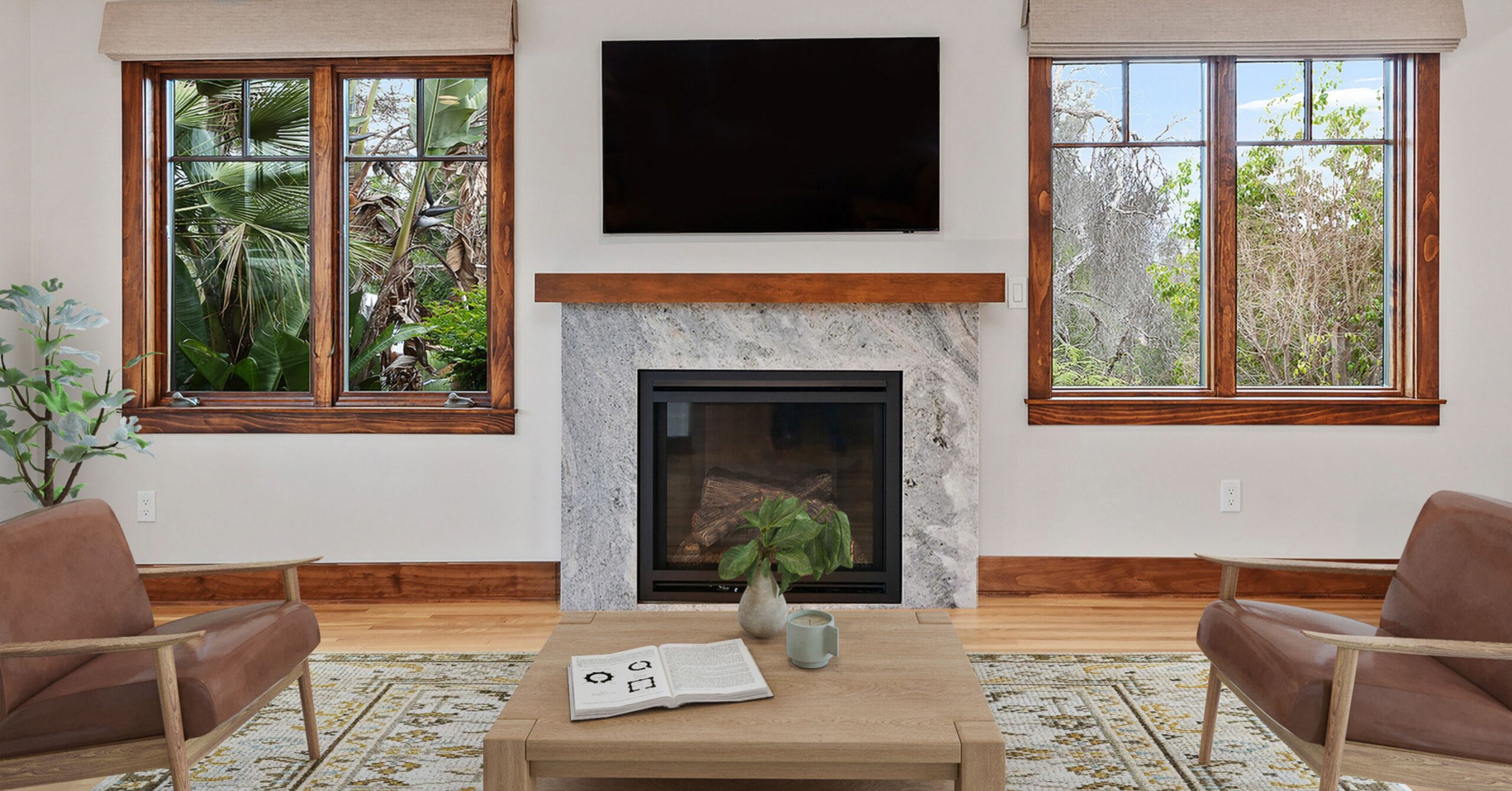 Remodeled South Park Craftsman living room featuring a restored fireplace with a stone surround, original wood-trimmed windows, hardwood floors, and an open layout designed to improve flow while preserving the home's historic character.