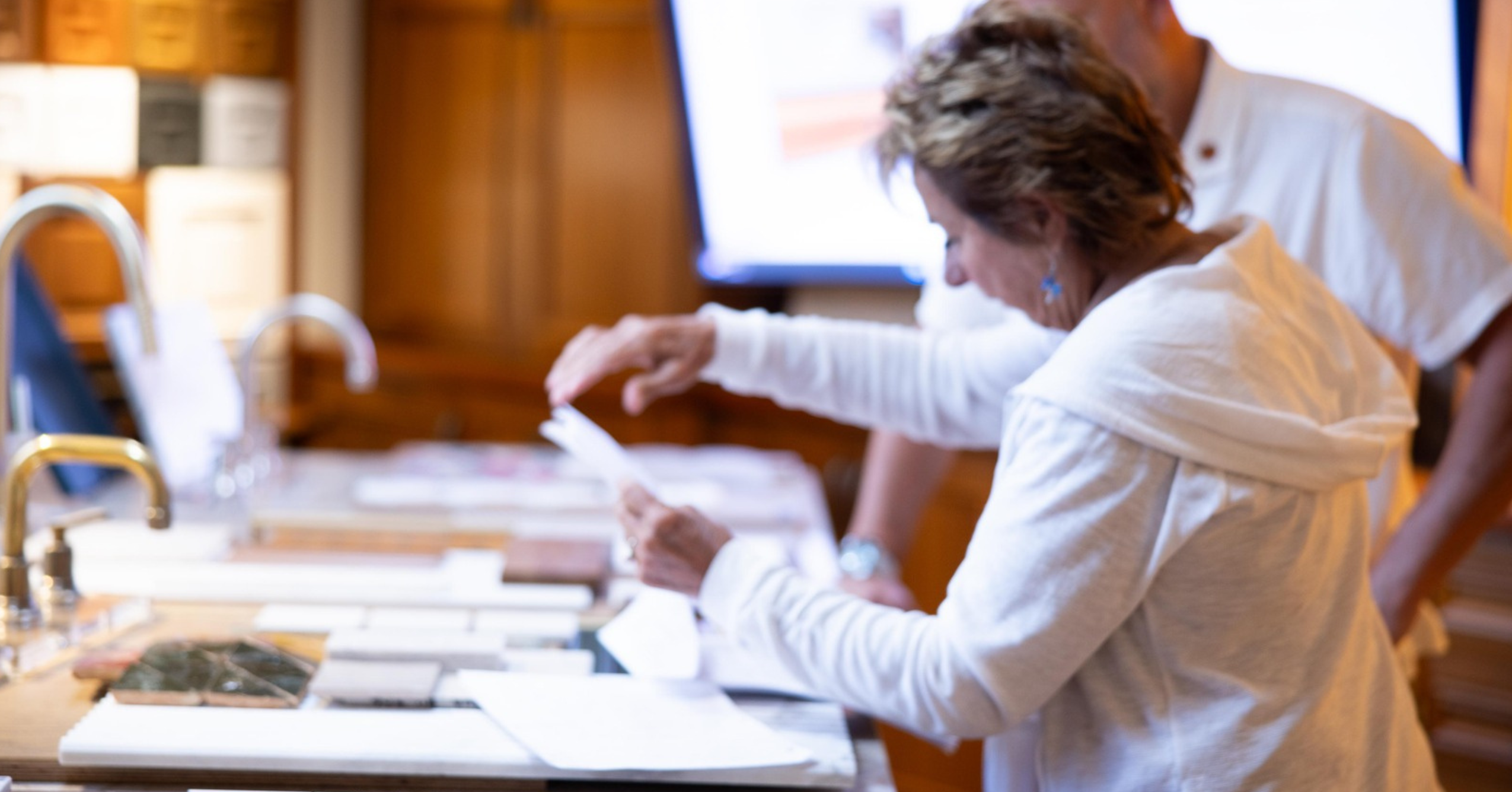 Homeowner reviewing remodeling options, material samples, and project information during an educational home renovation event.
