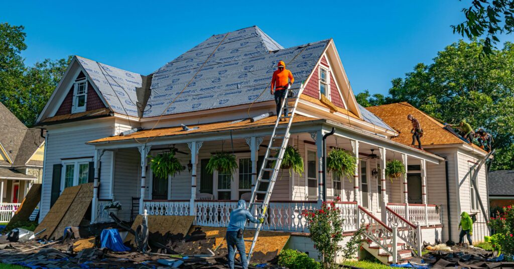 Licensed roofing contractors replacing the roof on a historic home during a permitted exterior renovation project.