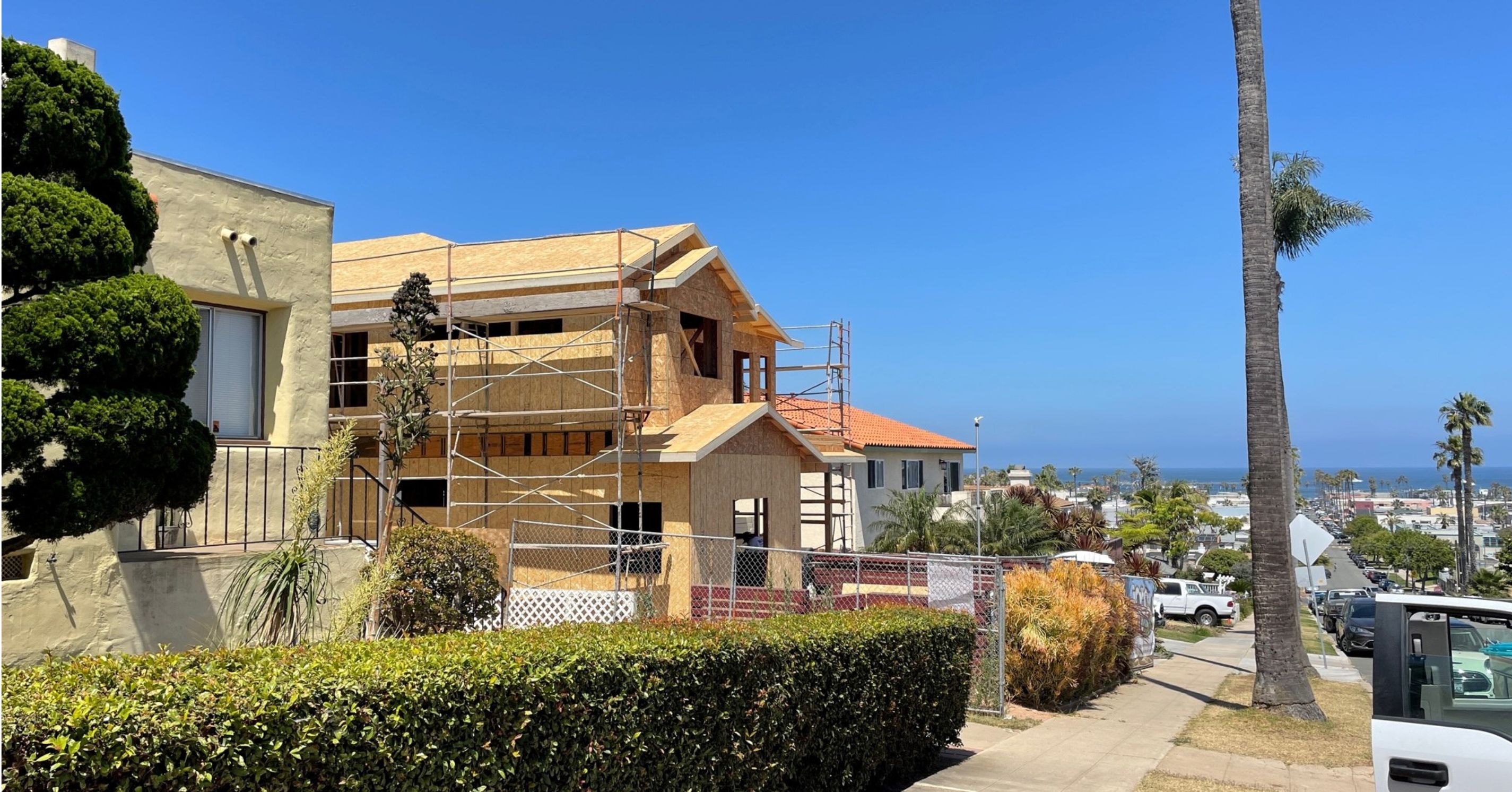 Two-story home addition under construction with framing and scaffolding during the structural phase of a San Diego remodel.
