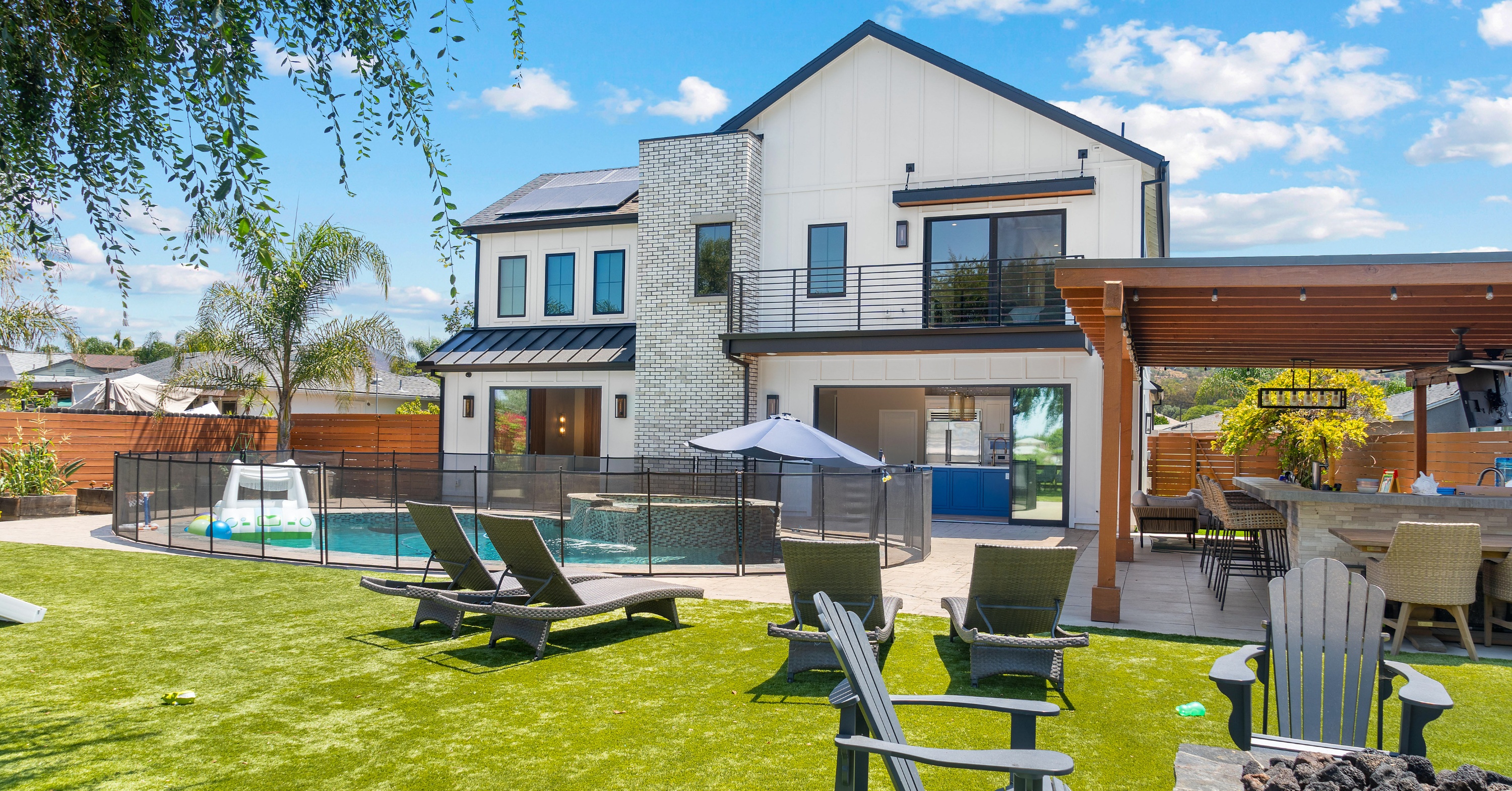 Remodeled two-story San Diego home with a backyard pool, covered outdoor kitchen, patio seating, and a second-story primary suite addition.