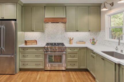Spacious remodeled kitchen with sage green cabinetry, quartz countertops, stainless steel appliances, and large windows.