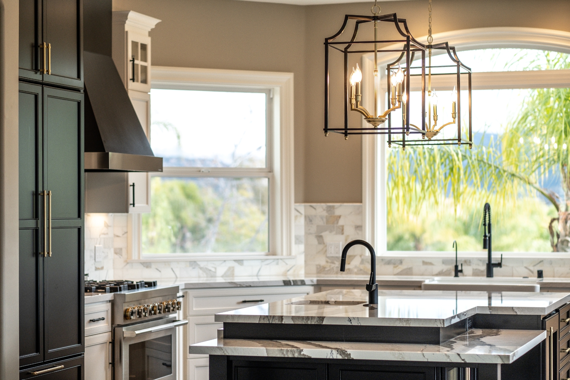 Alpine kitchen remodel with black cabinetry, white perimeter cabinets, a multi-level stone island, professional range, and lantern pendant lights.