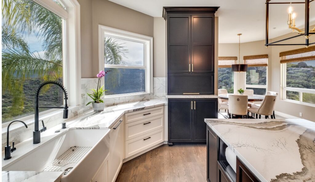 Alpine kitchen remodel with a black island, white perimeter cabinetry, professional range, stone countertops, and oversized lantern pendant lights.