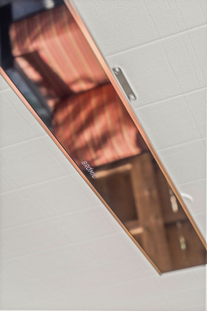 Close-up of a ceiling-mounted radiant heater installed beneath a white paneled patio cover.