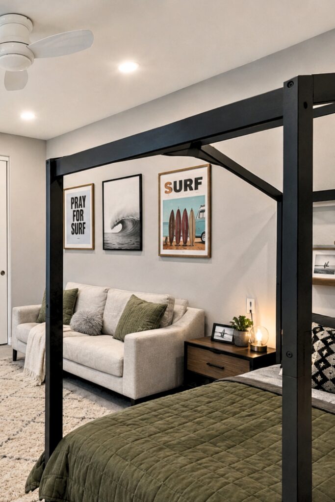 Modern teen bedroom with a black canopy bed, green bedding, small sofa, and framed surf artwork.