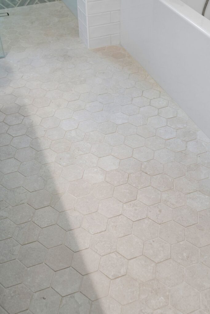 Pale hexagonal bathroom floor tile beside a white bathtub in a Rancho Bernardo bathroom remodel.
