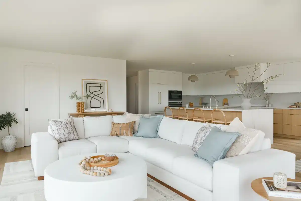Coastal-style living room connected to an open kitchen with wood cabinets.