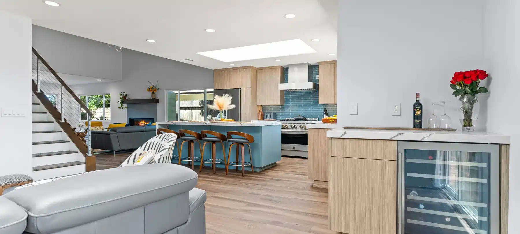 Connected kitchen and living room with wood cabinetry and a blue island.