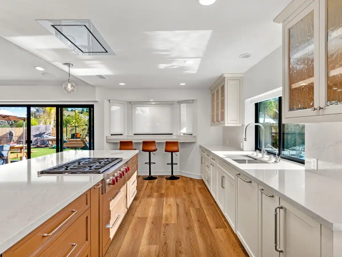 Open kitchen with a wood island, white cabinetry and sliding doors to the yard.