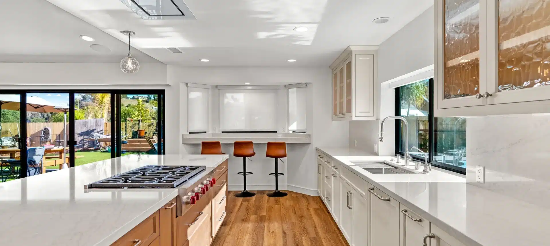 Open kitchen with a wood island, white cabinetry and sliding doors to the yard.