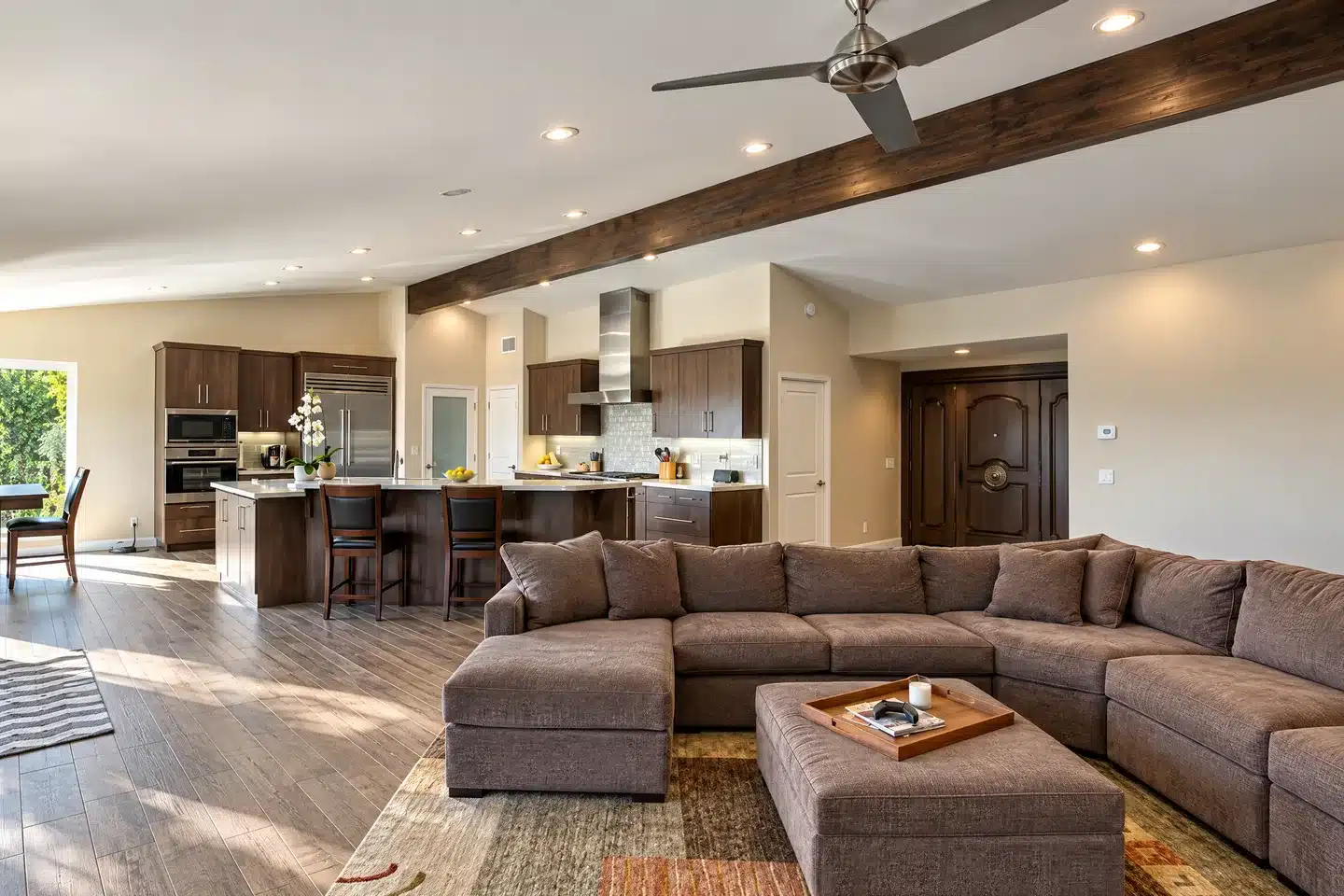 La Jolla kitchen and family room with wood cabinetry and an exposed ceiling beam.