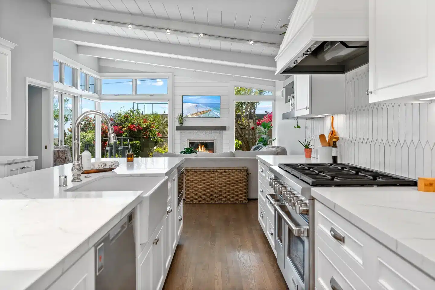 La Jolla kitchen opening to a living room with a fireplace and large windows.