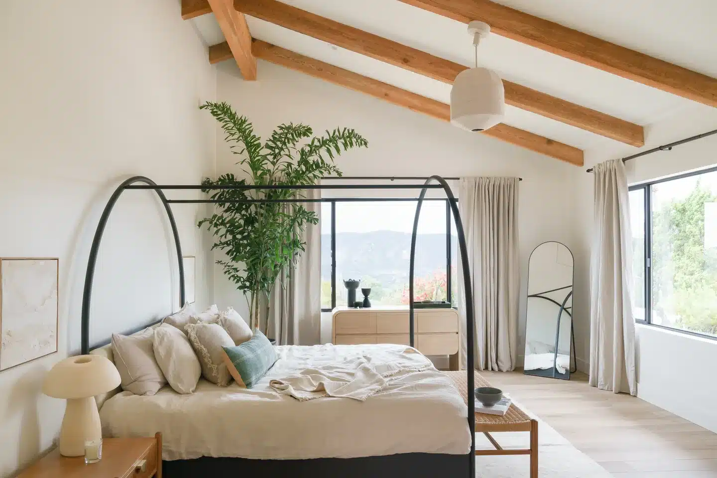 La Jolla primary bedroom with exposed wood beams and large windows.