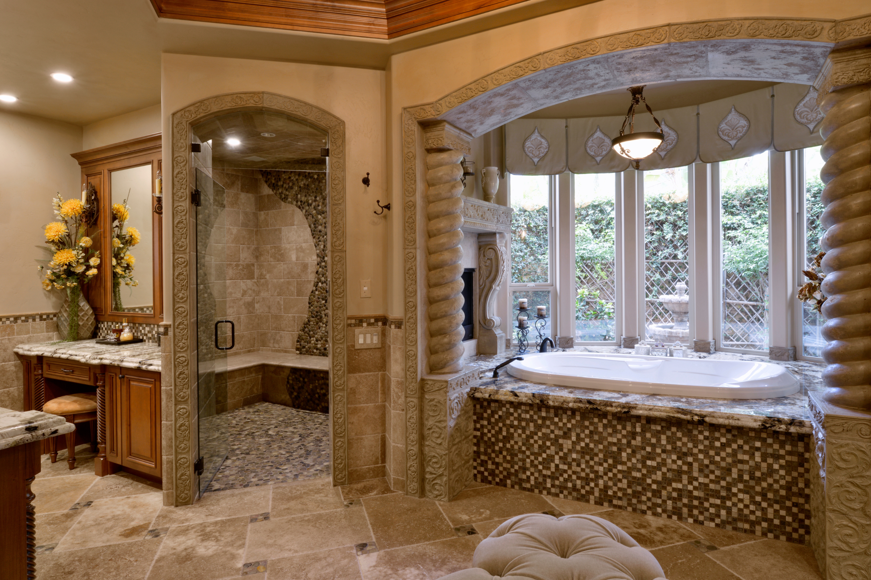 Primary bathroom remodel with tiled shower, built-in bench, jetted tub, stone surround and custom wood vanity.